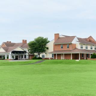 A scenic view of two distinct houses set against a lush green lawn.