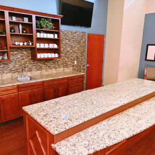 A modern kitchen with granite countertops and wooden cabinets.