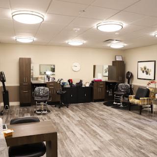 A well-designed interior of a modern hair salon, featuring comfortable seating and organized workstations.