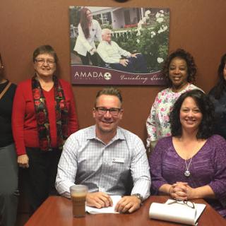 A diverse group of professionals gathered for a meeting in an office setting.
