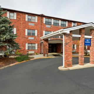 A brick hotel building with an entrance and driveway.