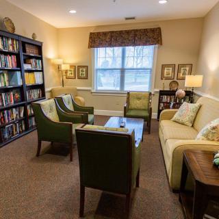 A cozy living room with comfortable seating, a bookshelf filled with books, and warm lighting.