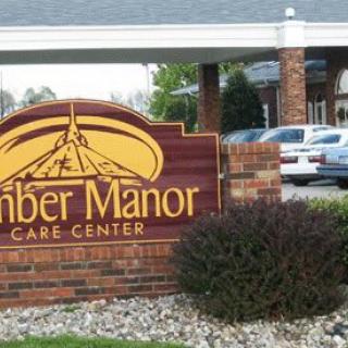 Entrance sign for Timber Manor Care Center with surrounding landscaping.