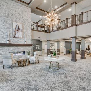 A modern lobby area featuring elegant decor, a grand chandelier, and spacious seating arrangements.