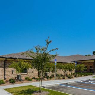 A modern commercial building with a parking lot on a clear day.