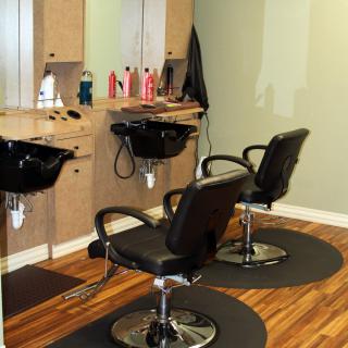 A tidy and inviting hair salon with styling stations and mirrors.