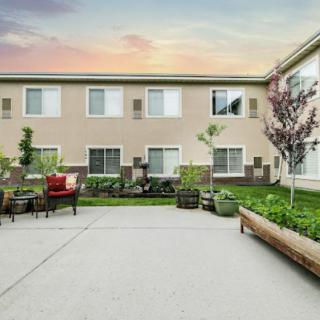 A peaceful courtyard with comfortable outdoor seating and lush landscaping at sunset.
