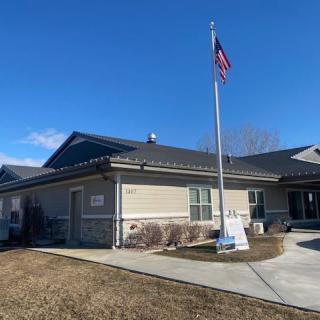 A building with an American flag on a sunny day against a clear blue sky.