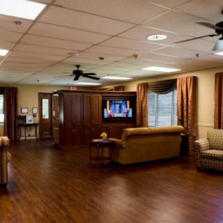 A cozy living room interior with sofas, a television, and wooden flooring.