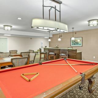 A stylish recreation room featuring a red felt pool table and elegant lighting.