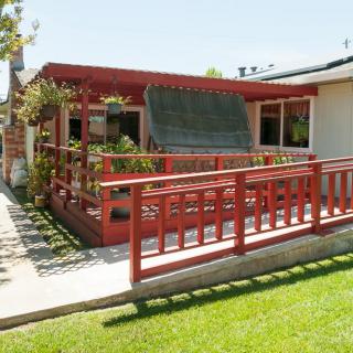 A house with a red porch and ramp on a sunny day.