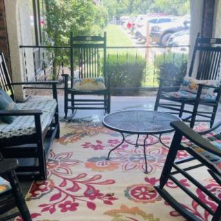 A cozy outdoor porch with rocking chairs and a decorative rug.