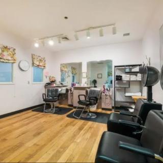 A modern salon interior with styling chairs, mirrors, and hairdryers.
