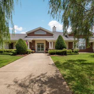A suburban house with a well-maintained front yard and a long driveway.