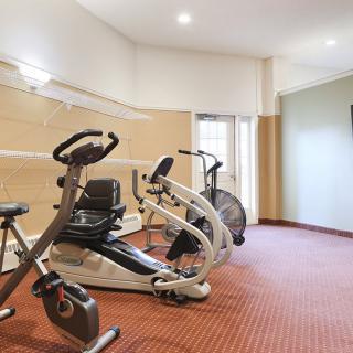 A small gym with various exercise equipment including stationary bikes.