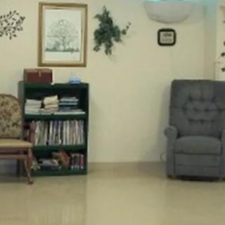 A cozy living room with a bookshelf and seating area.