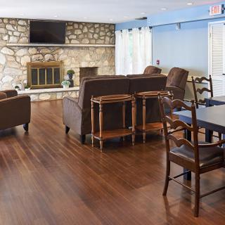 A cozy living room with a stone fireplace and wooden flooring.