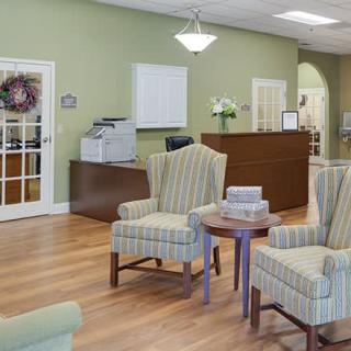 A cozy waiting room with comfortable chairs and a reception desk.