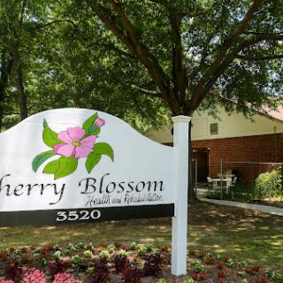 Entrance sign for Cherry Blossom, surrounded by lush greenery.