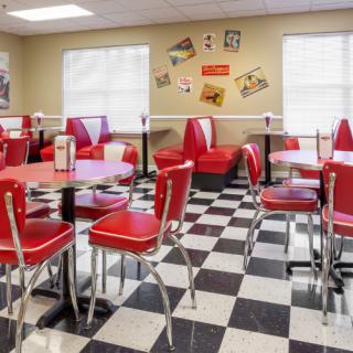 A vintage-style diner with red booths and checkered flooring.