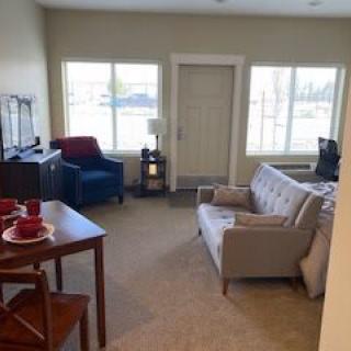 A cozy living room with a couch, chair, and television.