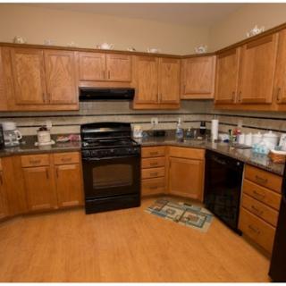 A cozy kitchen featuring wooden cabinets, granite countertops, and modern appliances.
