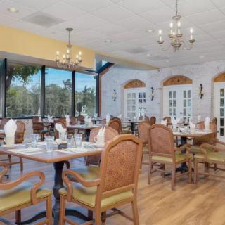 An inviting restaurant dining area with elegant chandeliers and large windows.