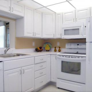 A modern kitchen with white cabinets and appliances.