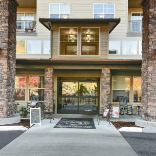 The entrance of a modern building featuring stone columns and large glass doors.