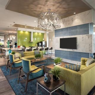 A modern and colorful living area with contemporary furnishings and a stylish chandelier.