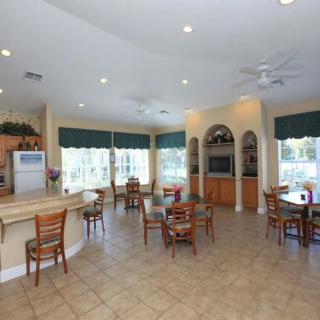 A spacious kitchen and dining area with multiple tables and chairs, large windows, and modern appliances.