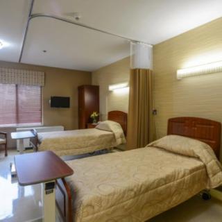 A well-organized hospital room featuring two beds with a calm and clean environment.