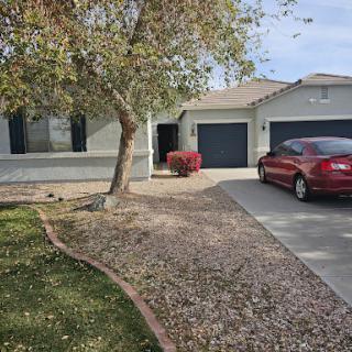 A charming residential house with a landscaped front yard and a parked car.
