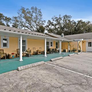 A small yellow motel with a parking lot and surrounding trees.