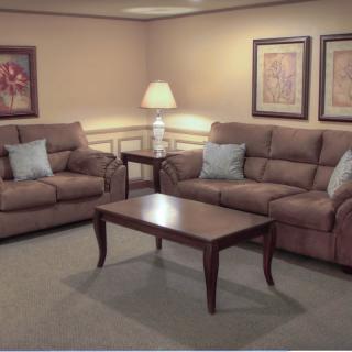 A cozy living room with comfortable sofas, a wooden coffee table, and warm lighting.