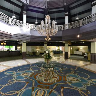 A luxurious hotel lobby featuring a grand chandelier and elegant decor.