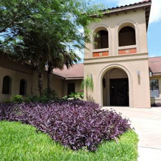 A charming architectural structure surrounded by beautiful landscaping.