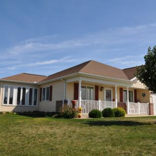 A single-story house with a lawn under a clear blue sky.
