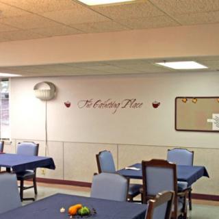 A dining area with tables and chairs, decorated with a balloon and wall art.