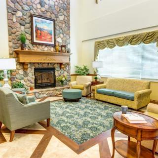 A cozy living room with a stone fireplace, comfortable seating, and elegant interior decor.