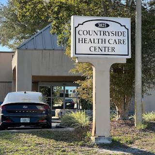 The entrance to Countryside Health Care Center, featuring a clear sign and parked vehicle.