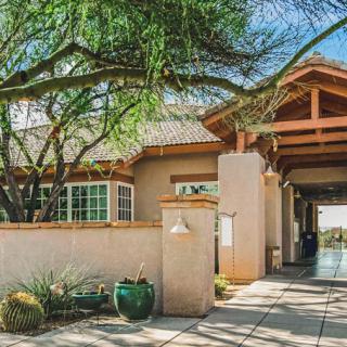 A modern desert home with a tree and spacious entrance.