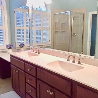 A well-lit bathroom with a double sink vanity and large mirrors.