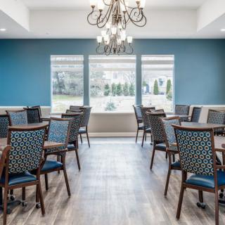 A well-lit dining room with elegant furnishings and a chandelier.