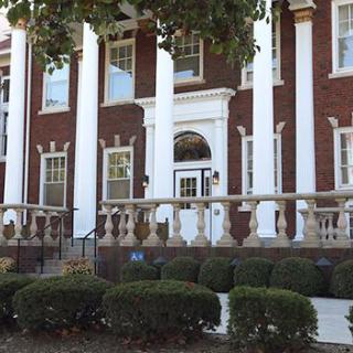 A historic brick building with large columns and an ornate entrance.