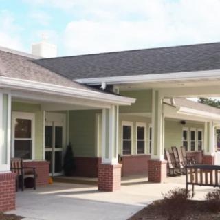A residential building with a covered porch and outdoor seating.