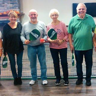 A cheerful group of seniors ready to enjoy a game of pickleball.