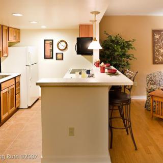 A cozy kitchen area with a breakfast bar, complete with bar stools and modern appliances.