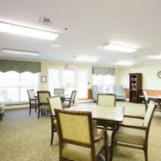 A well-lit dining area with several tables and chairs arranged for seating.