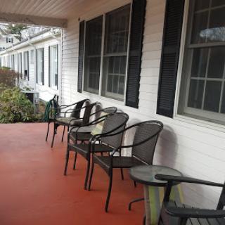A cozy porch featuring several chairs, perfect for enjoying a quiet moment outdoors.